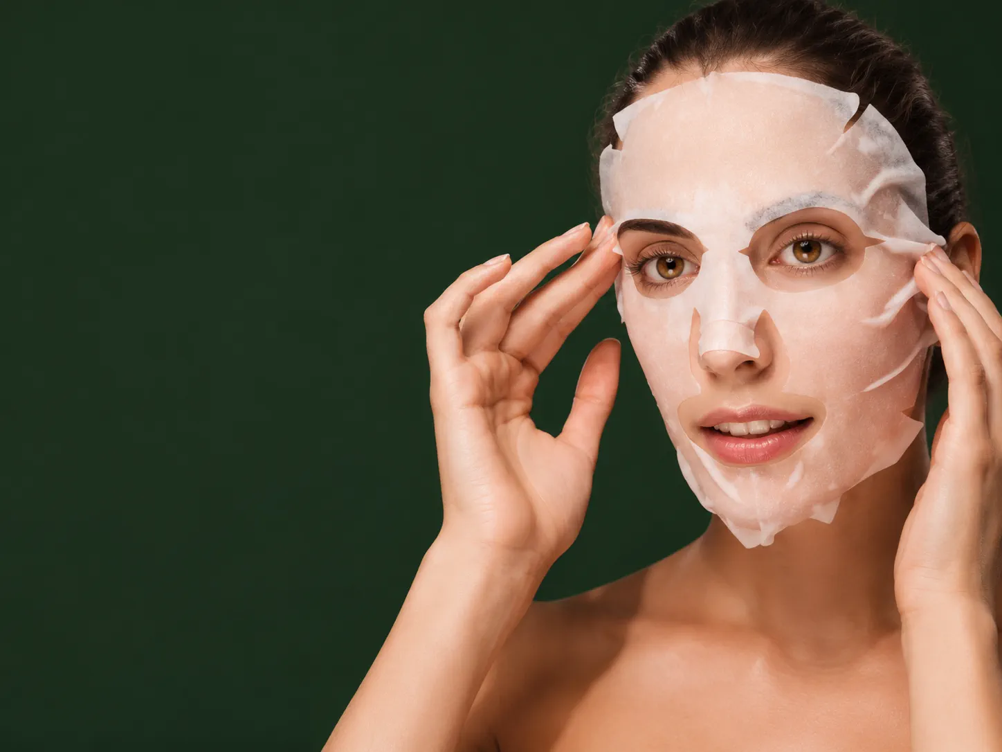Woman applying a sheet mask